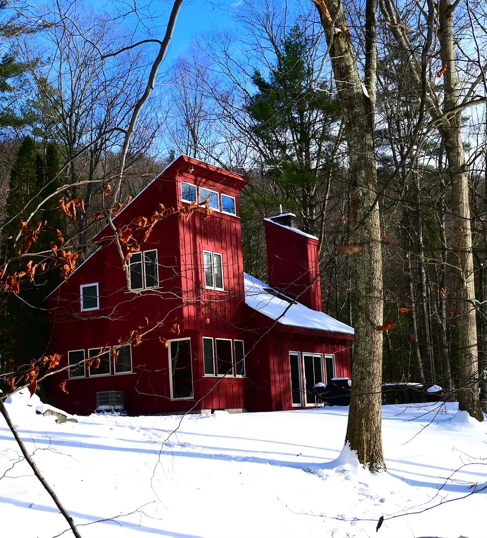 The red chalet after a fresh snowfall, under a blue winter sky