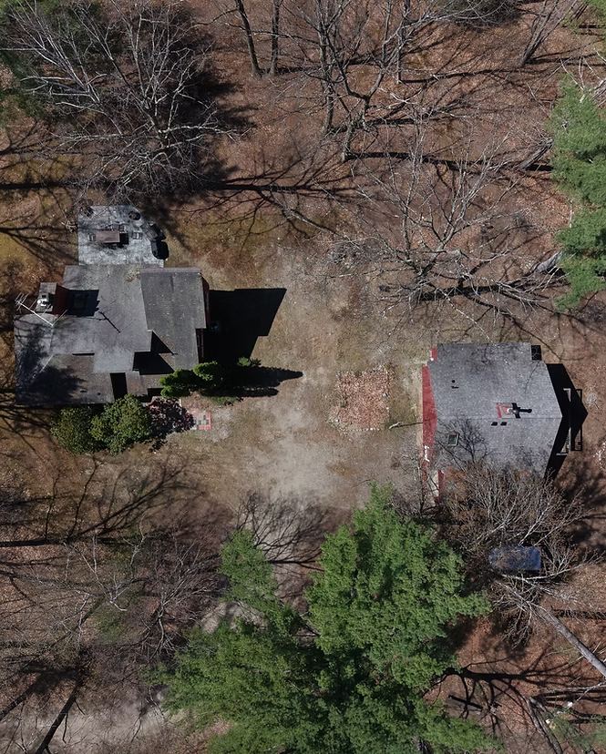 Top-down drone view of both roofs in the forest
